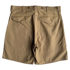 Puede incluir: Pantalones cortos color caqui con dos bolsillos traseros y cierre de bot&oacute;n. Los pantalones cortos tienen un dise&ntilde;o cl&aacute;sico con un ajuste a medida. La tela parece ser una mezcla de algod&oacute;n duradera, adecuada para ropa casual. Los pantalones cortos tienen trabillas y cierre de bot&oacute;n.