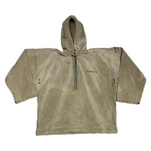 Può includere: Giacca anorak beige con cappuccio, zip e testo ricamato. La giacca ha un cappuccio con coulisse, maniche lunghe e chiusure a scatto sui polsini. L'indumento è di colore beige.