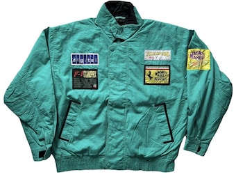 May include: A green jacket with multiple patches, including "Champion", "F-1 Grandprix", "Magneti Marelli Ferrari", "digital", and "Jacky Ickx".