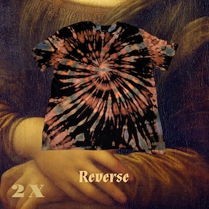 May include: A black, tie-dye t-shirt with a spiral pattern in shades of orange, pink, and blue. The shirt is labeled "Reverse" and sized "2X". The shirt is a casual wear item.