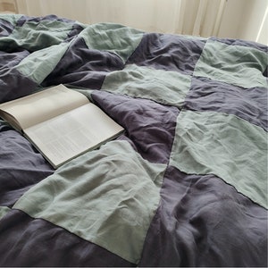May include: A checkered duvet cover with a patchwork design in shades of green and purple. The duvet cover is made of linen and has a relaxed, casual look.
