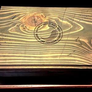 May include: A wooden box with a dark green stain and a circular logo that reads "Seafire Gourmet Hot Sauces & Flavor Goodness".