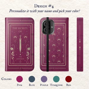 May include: A personalised phone case with a burgundy background and gold accents. The case features a design of a book with the text "The Secrets Of" and a sword. The case also has a strap and a camera cutout. The colours available are pink, blue, purple, turquoise, and red.