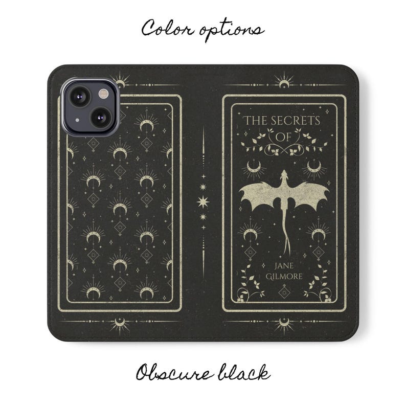 May include: Black phone case with a pattern of moons and stars. The back of the case features a white dragon with the text "The Secrets of Jane Gilmore".