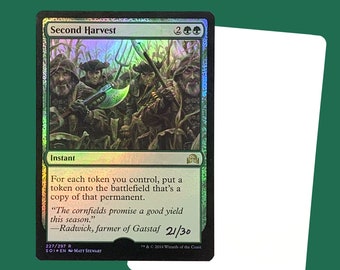 Könnte beinhalten: Eine grüne, blaue und schwarze Magic: The Gathering Karte mit dem Text "Second Harvest" und den Manakosten "2GG". Die Karte ist ein Instant und lautet: "Für jeden Token, den du kontrollierst, lege einen Token auf das Schlachtfeld, der eine Kopie dieses Permanenten ist." Die Karte enthält auch ein Zitat aus der Geschichte des Spiels: "Die Maisfelder versprechen einen guten Ertrag in dieser Saison." -Radwick, Bauer von Gatstaf 21/30.