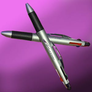May include: Two silver and black multi-function pens with a stylus tip. The pens have the text "18 years Cartoon Custom GO SCRIBBLE" printed on them.