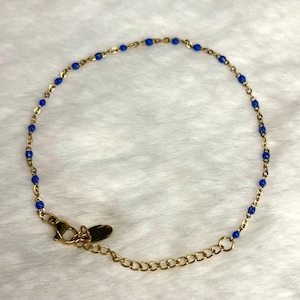Goldfarbenes Edelstahlarmband mit blauen Perlen