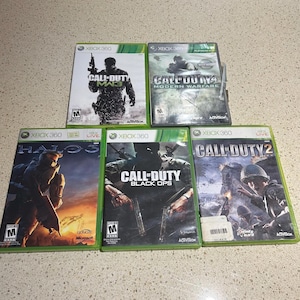 Puede incluir: Una colección de seis cajas de juegos de video para Xbox 360. Los juegos son Call of Duty: Modern Warfare, Call of Duty: Black Ops, Call of Duty 2, Call of Duty: MW3 y Halo 3.