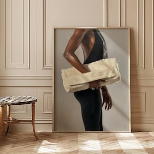 May include: A framed artwork depicts a person in a black dress holding a large, cream-colored faux fur clutch. The artwork is set against a neutral background, with a hint of light. The overall aesthetic is elegant and sophisticated.