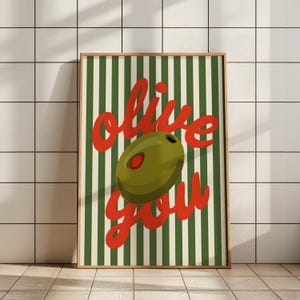 May include: A green and white striped poster with the text "olive you" in red lettering. A green olive is centred on the poster.