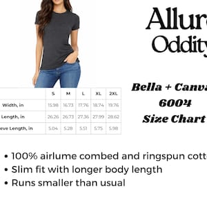 May include: A dark gray Bella + Canvas 6004 t-shirt with a crew neck, worn with blue jeans. The image includes a size chart with measurements in inches and the text "Allure Oddity". The shirt is made of 100% airlume combed and ringspun cotton.
