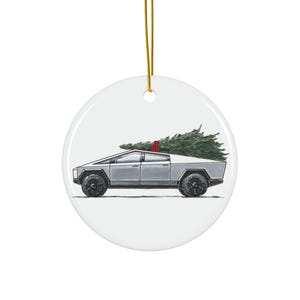 Op de afbeelding: Witte keramische kerstversiering met een zilveren pick-up truck met een kerstboom. De truck heeft zwarte wielen en een rode accentkleur. Een gouden draad is bevestigd.
