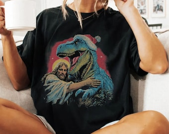 Jesus Holding Dinosaur Christmas Tee Vintage 90s Retro T-Rex Shirt Holiday Tee Funny Christian Parody Santa Dino Tee Conspiracy Theorist