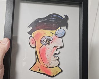 May include: A framed illustration of a colorful cartoon face with a black and white background. The artist's signature, "Matt Cabrera", is in the bottom right corner.