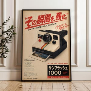 May include: A vintage-style poster featuring a black and cream Sunflash 1000 instant camera with a rainbow stripe. The poster includes Japanese text, a red shutter button, and a photograph ejecting from the camera base on a light beige background.