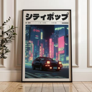 May include: Framed art print featuring a black car driving on a city street at night. The artwork has a retro, neon aesthetic with Japanese text at the top. The city is illuminated with pink and blue lights.