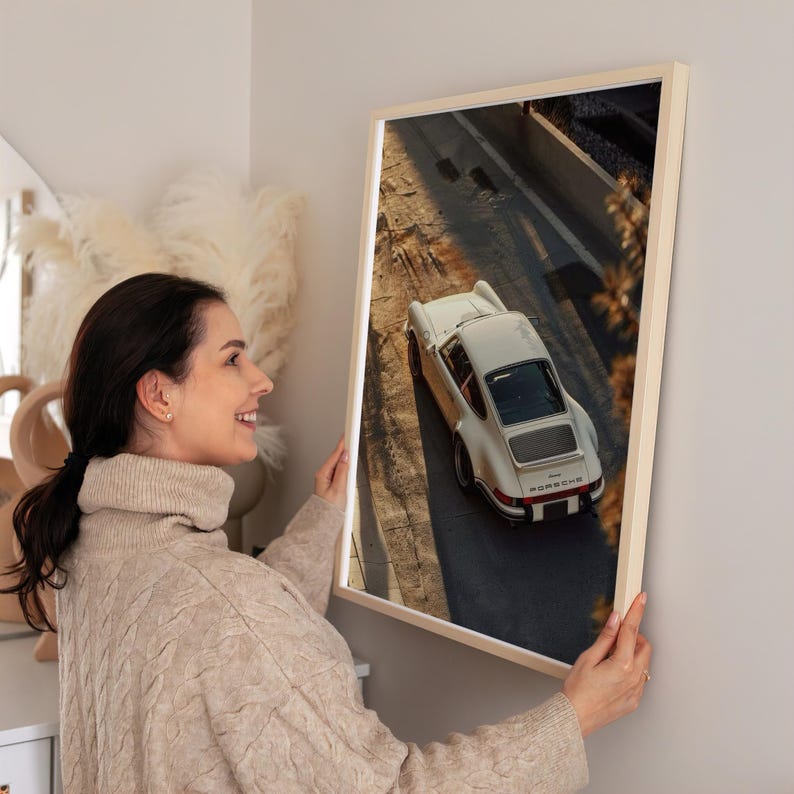 Vintage Porsche 911 captured in warm golden-hour light, highlighting the classic car's sleek curves and timeless design. The automotive wall art features soft shadows and earthy tones for a nostalgic, retro vibe. Displayed in a cozy living space, perfect for car enthusiasts and collectors.