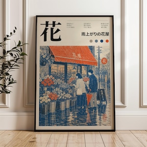 May include: A framed poster featuring a Japanese street scene with a flower shop under a red awning. Two figures stand before buckets of flowers on a rainy street. The text includes the large kanji character for flower and the phrase 雨上がりの花屋.