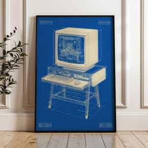 May include: Blueprint-style print of a vintage computer setup, featuring a cream-colored monitor, keyboard, and mouse on a wooden desk. The design is rendered in white lines against a vibrant blue background, framed in black.