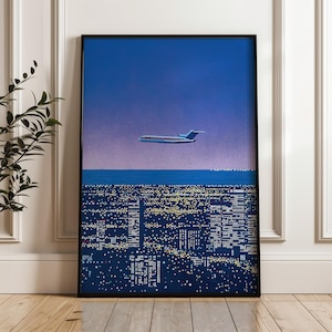 以下が含まれることがあります： 夜の街の上を飛ぶ旅客機を描いた、額入りのアートプリント。 青と紫の空、濃い青の海、窓が光る都市景観が特徴です。 飛行機は白を基調とし、赤と青のアクセントが施されています。