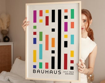 May include: A framed poster with a geometric design in various colors, including red, yellow, blue, green, and black. The poster reads "BAUHHAUS JULY 1923 WEIMAR".