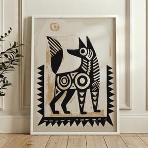 A young girl and an older woman are sitting together, with the girl holding up a framed artwork featuring a stylized dog design.