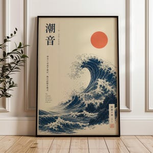 May include: A framed rectangular wall art print featuring a large dark blue ocean wave crashing against rocks. A solid orange circle represents the sun in the upper right. The print includes black Japanese text and English text reading Tide Sound.