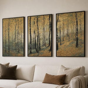 May include: A triptych of three vertical framed wall art prints depicting a forest scene with tall, slender trees. The colour palette features muted shades of golden yellow, olive green, and dark brown, creating a textured, painterly appearance.