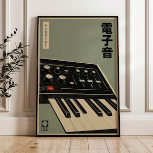 May include: A framed poster featuring a black analogue synthesiser with white keys, knobs, and a red button against a muted sage green background. The artwork includes vertical Japanese text in black and a small geometric logo in the bottom left corner.