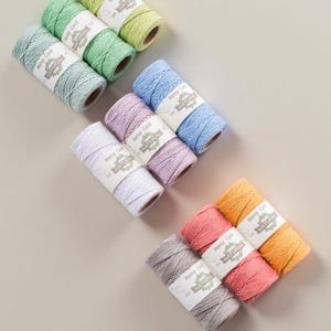 Puede incluir: Una taza de cerámica blanca con asa negra y el texto "But First, Coffee" en negrita negra. La taza se encuentra sobre un fondo borroso, sugiriendo un ambiente acogedor.