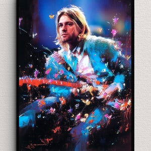 May include: A framed wall art print featuring a stylised, painterly portrait of a musician with blonde hair playing an electric guitar. The composition uses vibrant blue, purple, and orange brushstrokes with scattered colourful paint splatters.