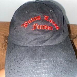 May include: Black baseball cap with red embroidered text that reads "Datos Locos Forever".
