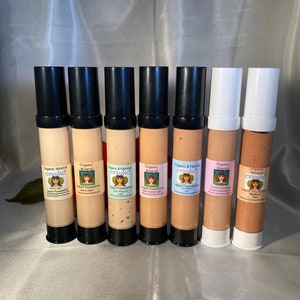 May include: Eight bottles of organic mineral makeup foundation in various shades. The bottles are labeled with the brand name "erzulie" and the words "Organic Mineral Makeup" and "Liquid Foundation".