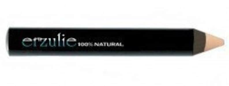 Puede incluir: Un l&aacute;piz de delineador de ojos negro con el nombre de la marca "erzulie" en verde azulado y el texto "100% NATURAL" en blanco. El l&aacute;piz tiene una punta marr&oacute;n claro.