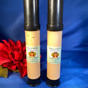May include: Two tubes of organic and natural liquid foundation in the shade Cool/Neutral Light. The tubes are black with a white label that says "Organic & Natural erzulie Liquid Foundation Cool/Neutral Light www.progressinhealth.com".