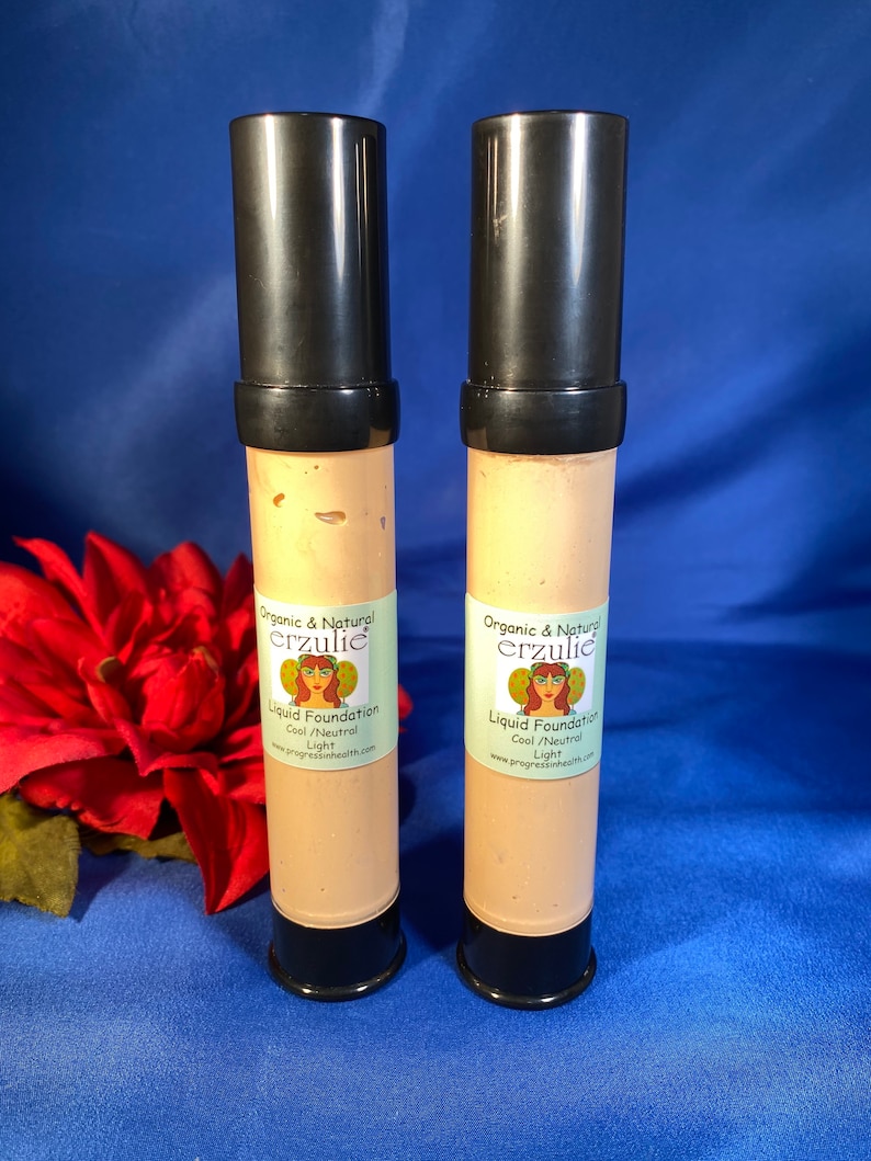 May include: Two tubes of organic and natural liquid foundation in the shade Cool/Neutral Light. The tubes are black with a white label that says "Organic & Natural erzulie Liquid Foundation Cool/Neutral Light www.progressinhealth.com".