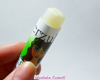 May include: A white lip balm tube with a green and white label featuring a cartoon woman with green eyes and a floral headband. The label reads "Erzu" in black lettering.