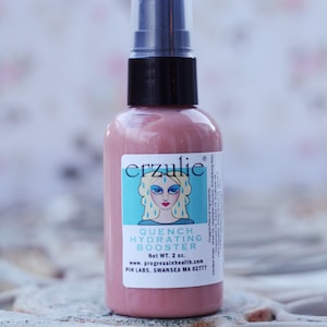 Könnte beinhalten: Eine rosa Flasche mit einer schwarzen Pumpenaufsatz und einem weißen Etikett, auf dem "erzulie" und "Quench Hydrating Booster" steht, sowie eine Comic-Illustration einer Frau mit blauen Haaren und blauen Augen. Das Etikett zeigt auch "Net WT. 2 oz." und "www.progressinhealth.com".