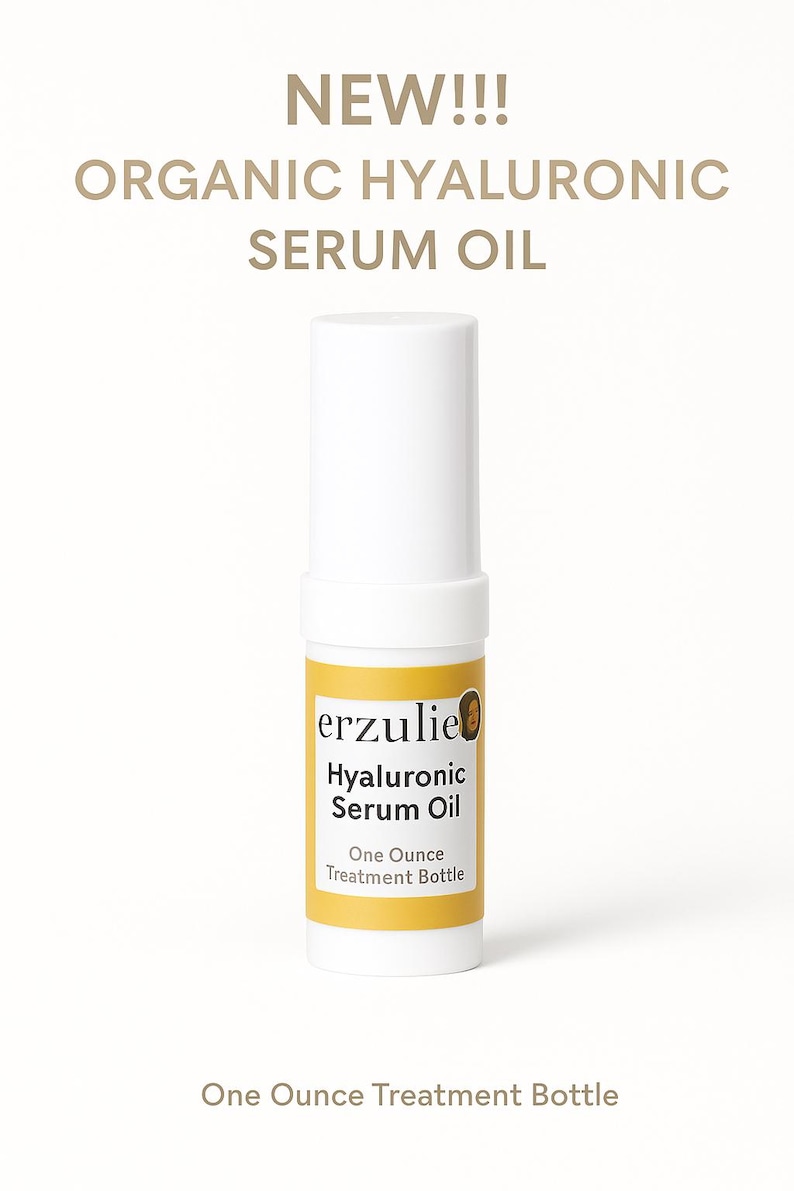 以下が含まれることがあります： 「erzulie Hyaluronic Serum Oil」と「One Ounce Treatment Bottle」と書かれた黄色のラベルが付いた白いボトルです。
