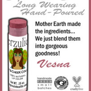 K&ouml;nnte beinhalten: Ein rosa-wei&szlig;es R&ouml;hrchen Lippenbalsam mit einem Frauenkopf auf dem Etikett. Das Etikett tr&auml;gt die Aufschrift "Erzuli" und "VCHEEK COLOR". Der Lippenbalsam wird als "Super Moist Shine Long Wearing Hand-Poured" beschrieben. Der Text lautet au&szlig;erdem "Mother Earth made the ingredients... We just blend them into gorgeous goodness! Vesna". Der Lippenbalsam ist handgefertigt, in kleinen Chargen, tierversuchsfrei und ohne Wismut-Oxychlorid.