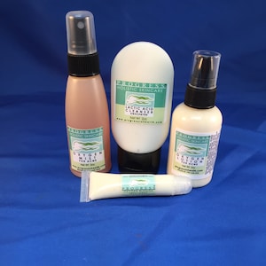 May include: Four bottles of skincare products with the brand name "Progress Holistic Skincare" on the labels. The products are a lactic acid cleanser, an oxygen mist for acne, an oxygen lotion for acne, and an oxygen blemish treatment.