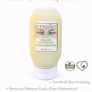 May include: A light yellow Erzulie Organic Gentle Eye Makeup Remover bottle. The label features the brand name, product description, and a graphic of blue eyes. The bottle is 2 oz and has a white base. The product is organic, gentle, and vegan-friendly.