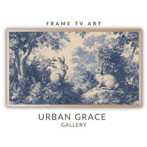 May include: A vintage-style illustration of two white rabbits in a blue and white forest setting. The image has a faded, antique look and is framed in a light wood frame. The text "FRAME TV ART" appears at the top of the image and "URBAN GRACE GALLERY" appears at the bottom.