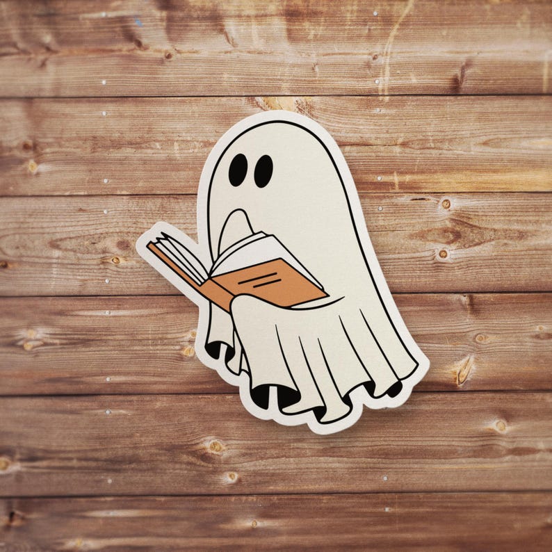 May include: A white ghost with two black eyes is reading a brown book with a white cover. The ghost is wearing a white sheet with a ruffled bottom.