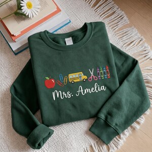 Embroidered Teacher Icons Custom Name Sweatshirt, Apple Crayon Bus Scissors Back to School Shirt