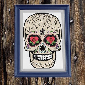 May include: A colourful sugar skull with red hearts for eyes, a black spiderweb on the forehead, and a star on the top of the head. The skull is decorated with colourful swirls and dots.
