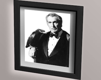 Può includere: Foto in bianco e nero di un uomo in smoking con un corvo appollaiato sulla spalla. L'uomo guarda la fotocamera e il corvo guarda altrove.