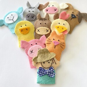 May include: Set of ten felt finger puppets featuring various farm animals, including a cow, pig, sheep, chicken, duck, horse, cat, dog, and a farmer. The puppets are all brightly colored and have friendly faces.