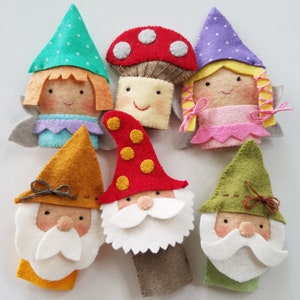 May include: Set of six felt finger puppets featuring a mushroom, two gnomes, and three fairies. The fairies have green, purple, and pink dresses with yellow hair. The gnomes have red, orange, and green hats.