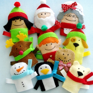 Puede incluir: Conjunto de diez marionetas de dedo de fieltro con una variedad de personajes navideños, incluyendo Papá Noel, un elfo, un reno, un muñeco de nieve, un pingüino, un hombre de jengibre, un perro y un oso polar. Las marionnettes son todas de colores brillantes y tienen caras amigables.